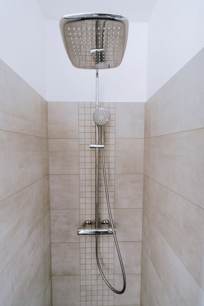 Moderne Dusche mit eleganten Fliesen und zwei verschiedenen Duschköpfen.