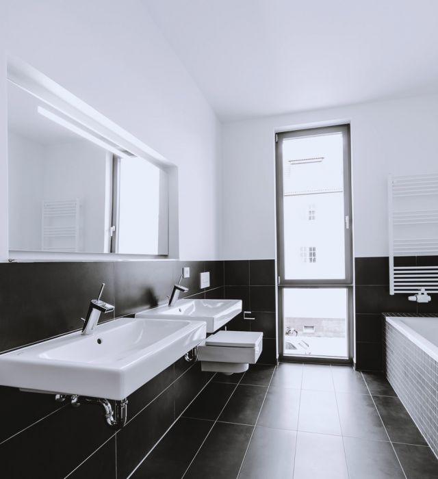 Modernes Badezimmer mit Doppelspülbecken, großer Spiegelfront und Blick nach draußen.