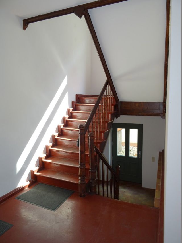Historisches Treppenhaus mit Holzstufen und Geländer, nostalgischer Charme mit Tageslichteinfall.