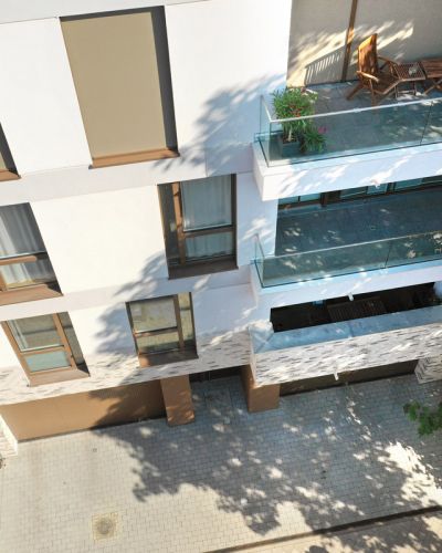 Moderne Wohnanlage mit Balkonen und grüner Umgebung aus Vogelperspektive.