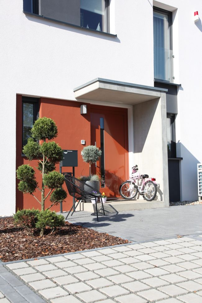 Gemütliche Hauseingangssituation mit Terrasse, Fahrrädern und Topfpflanzen.